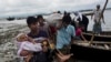 A Rohingya ethnic minority from Myanmar carries an elderly woman as they alight from a local boat on which they crossed a river, after crossing over to the Bangladesh side of the border near Cox's Bazar's Dakhinpara area, Saturday, Sept. 2, 2017.