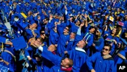 In this May 31, 2014 file photo, graduates throw their caps in the air in triumph at the University of Delaware's commencement ceremony in Newark, Del. (AP Photo/Emily Varisco)