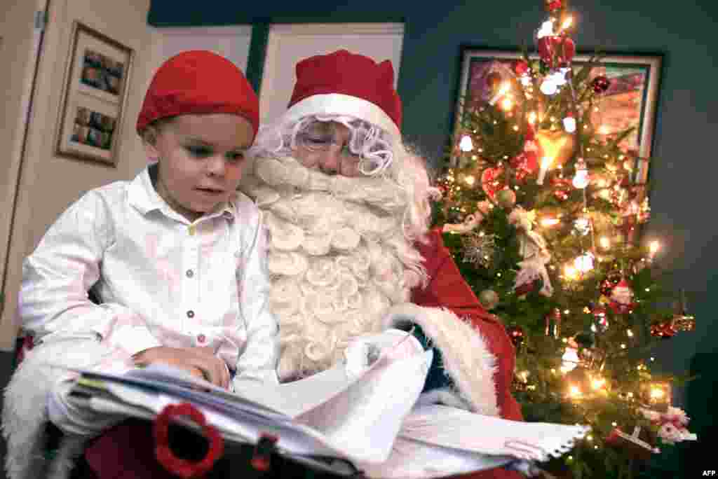 Un homme habillé en Père Noël donne des cadeaux de Noël dans une maison familiale à Espoo, en Finlande, le 24 décembre 2017.