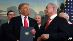 FILE - In this March 25, 2019 file photo, President Donald Trump smiles at Israeli Prime Minister Benjamin Netanyahu, right, after signing a proclamation at the White House in Washington.