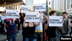 Residents hold up signs that read, "Metro workers: The people support you," outside Ana Rosa subway station during the fifth day of metro worker's strike in Sao Paulo, Brazil, June 9, 2014.