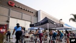 지난 15일 미국 캘리포니아주 컬버시티의 '사이클바' 짐에서 신종 코로나바이러스 예방을 위해 실내가 아닌 주차장에서 수업을 진행하고 있다. 