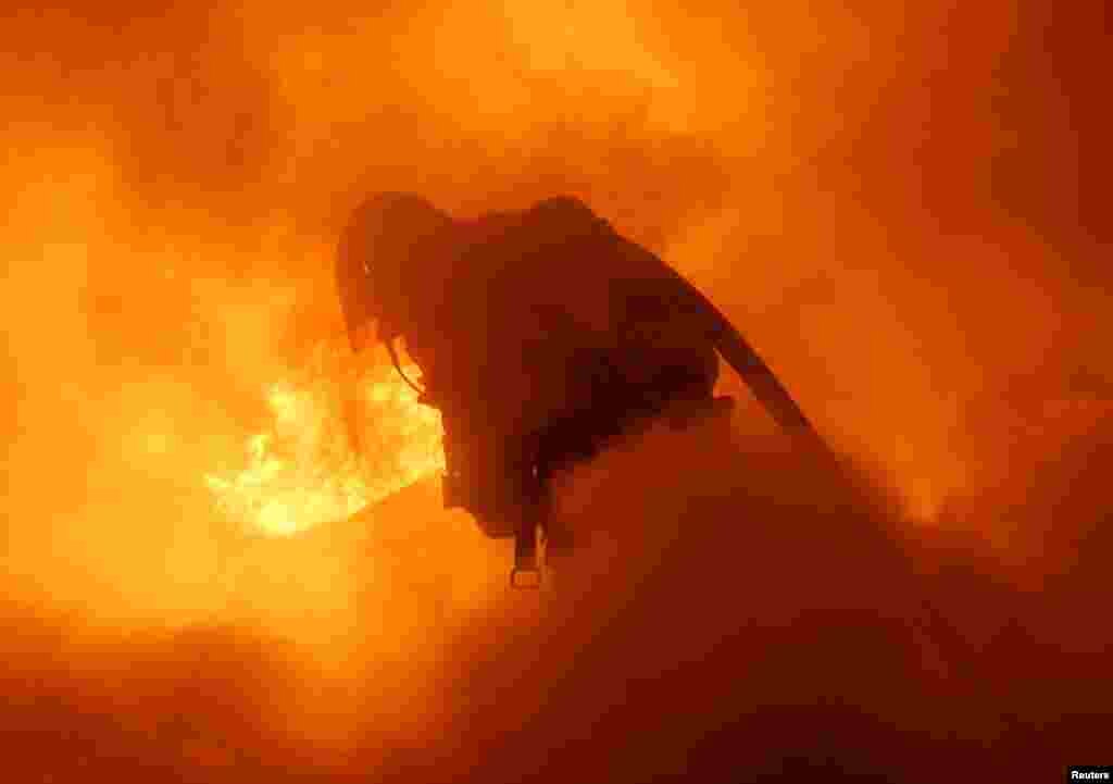 អ្នក​ពន្លត់​អគ្គិភ័យ​ពន្លត់​ភ្លើង​នៅ​ក្នុង​រថយន្ត​មួយ​អំឡុង​ថ្ងៃ​ចូល​ឆ្នាំ​ថ្មី​នៅទីក្រុង​ Douai​ ភាគ​ខាងជើង​ប្រទេស​បារាំង។