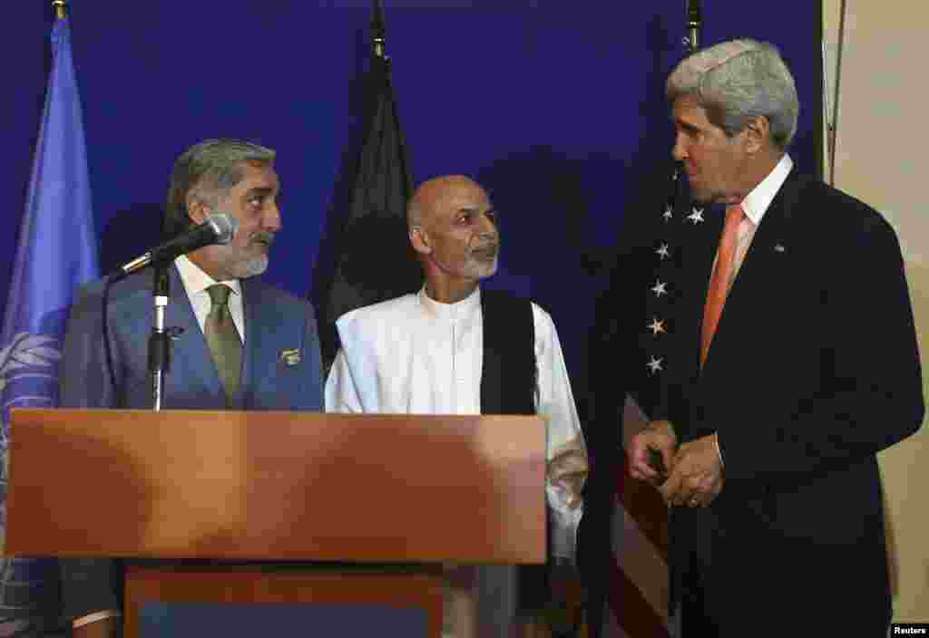 U.S. Secretary of State John Kerry speaks to Afghan presidential candidates Ashraf Ghani (center) and Abdullah Abdullah (left) during a news conference in Kabul, Aug. 8, 2014.