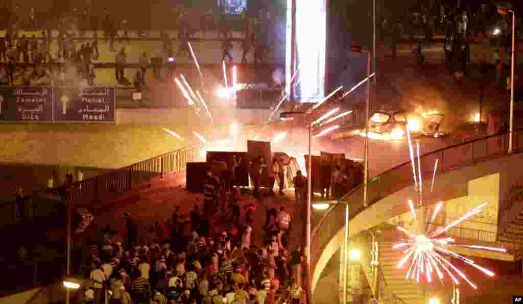 Supporters and opponents of Egypt&#39;s Islamist President Mohamed Morsi clash in Cairo, July 5, 2013. Tens of thousands of Islamists streamed across a Nile River bridge toward Tahrir Square, threatening a showdown moments after the top leader of the Muslim Brotherhood defiantly spoke before a cheering crowd of supporters, vowing to reinstate the ousted president and end military rule.