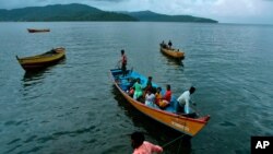 FILE - Fishermen and women return to their homes in Port Blair, in India's Andaman and Nicobar Islands archipelago, Sept. 6, 2007. Authorities say 10 cases have been detected among the Great Andamanese tribe, whose numbers have dwindled to 56.