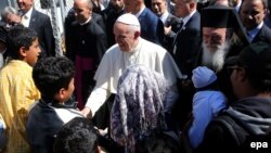 Le pape François, au centre, salue les enfants réfugiés à son arrivée au camp de ces derniers à Moria, sur l’ île de Lesbos, Grèce, 16 avril 2016. epa/ ORESTIS 