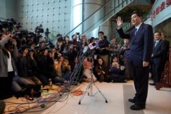 FILE - Newly-appointed head of China's liaison office in Hong Kong, Luo Huining, right, waves as he arrives for a media briefing at China's liaison office in Hong Kong, Jan. 6, 2020.