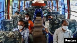 មនុស្ស​ម្នា​ពាក់​ម៉ាស់ជិះ​ក្នុង​រថយន្ដ​ក្រុង​មួយ​គ្រឿង​ ដើម្បី​ការពារ​កុំ​ឲ្យ​ឆ្លង​ជំងឺ​កូវីដ១៩ ទីក្រុង​ដាកា​ ប្រទេស​បង់ក្លាដែស ថ្ងៃ​ទី​២២ ខែមិថុនា ឆ្នាំ​២០២០។