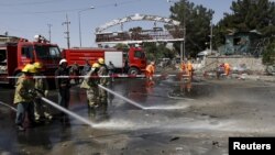 Afghan workers clear debris from the site of a car bomb blast at the entrance gate to the Kabul airport, Afghanistan, Aug. 10, 2015. 