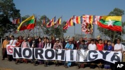 បាតុករ​មីយ៉ាន់ម៉ា​កាន់​បដា​នៅ​ខាង​ក្រៅ​ផែ Thilawa ដែល​នាវា​ម៉ាឡេស៊ី​ដឹក​ជំនួយ​មនុស្សធម៌​សម្រាប់​ជនជាតិ​ភាគ​តិច​រ៉ូហ៊ីងយ៉ា​នៅ​ក្នុង​ក្រុង​រ៉ង់ហ្គូន ប្រទេស​មីយ៉ាន់ម៉ា កាលពី​ថ្ងៃទី៩ ខែកុម្ភៈ ឆ្នាំ២០១៧។