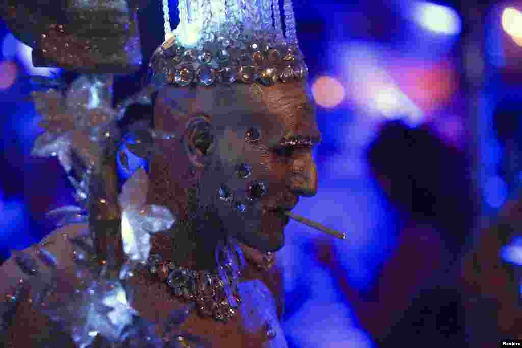 A man dressed as an ice queen smokes a cigarette during the West Hollywood Halloween Costume Carnaval, which attracts nearly 500,000 people annually in West Hollywood, California, Oct. 31, 2013. 