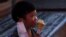 FILE - A child eats an ice cream in Xianning, Hubei province, China March 25, 2020.