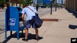 រូបឯកសារ៖ បុគ្គលិក​ប្រៃសណីយ៍​ម្នាក់​ប្រមូលយក​សំបុត្រ​ពី​ប្រអប់​​ប្រៃសណីយ៍​មួយ​កន្លែង​នៅក្នុង​ទីក្រុង Milwaukee កាលពី​ថ្ងៃអង្គារទី១៨ ខែសីហា ឆ្នាំ២០២០។