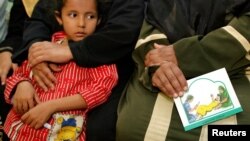 Une femme tient une carte contre les mutilations génitales féminines au cours d'une session pour éduquer les femmes à Minia, en Egypte, le 13 juin 2006. 