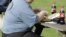 FILE - An overweight man eats his lunch on a park bench. Obesity has become a growing problem worldwide. 