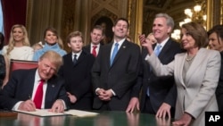 Presiden Donald Trump bergabung dengan pimpinan Kongres dan keluarganya, saat ia secara resmi menandatangani nominasi kabinetnya menjadi undang-undang, di Ruang Presiden Senat AS, di Gedung Capitol, Washington, 20 Januari 2017. (AP Photo/J. Scott Applewhite, Pool)