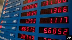 A board shows currencies exchange rates on the Champs Elysees in Paris, Jan. 6, 2015.