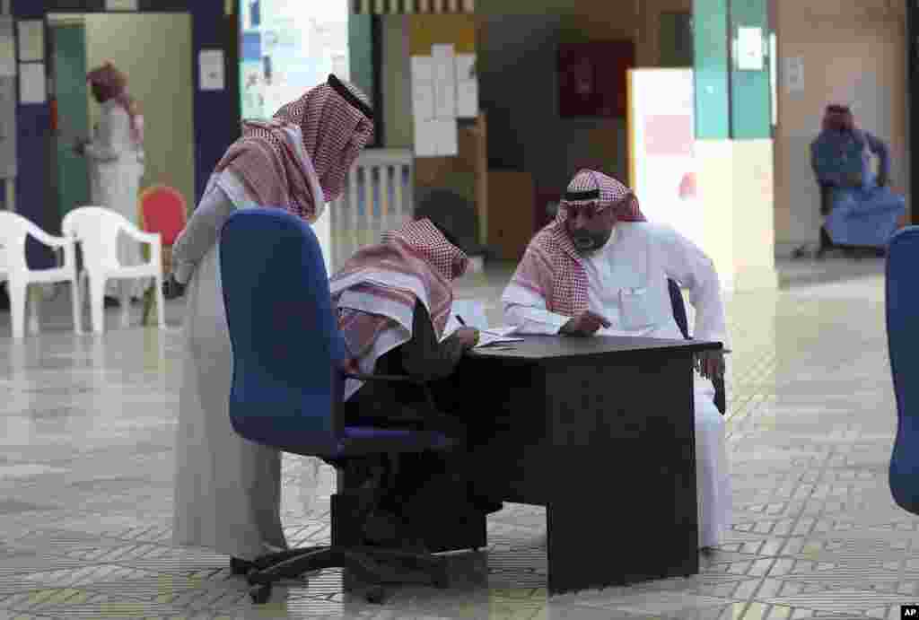 A Saudi man signs next to his name before casting his ballot.