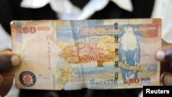 ARCHIVES - Un homme montre un billet de 50 000 Kwacha, la monnaie zambienne, à Lusaka le 23 janvier 2012.