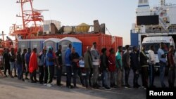 Para migran antre menunggu bantuan dari para anggota Palang Merah Spanyol setelah tiba dengan menggunakan kapal penyelamat di pelabuhan Algeciras, selatan Spanyol, 22 Juli 2018..
