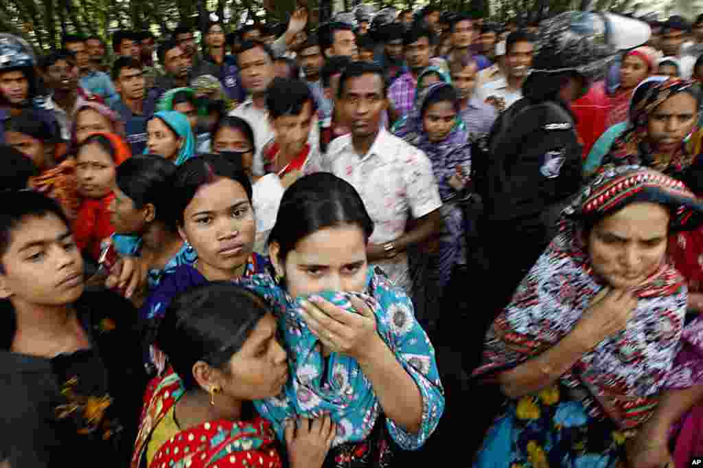 People look at a burnt garment factory outside Dhaka, Bangladesh, November 25, 2012.