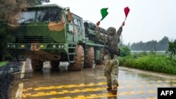 This handout photograph, taken on May 23, 2024, and released by the Eastern Theater Command of China's People's Liberation Army, shows a soldier leading a Chinese rocket launcher at a base during a military drill in eastern China's Fujian province.