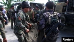 Philippine National Police (PNP) carry a body bag, containing a member of the Special Action Force, to a van in Mamasapano town, Maguindanao province, January 26, 2015.