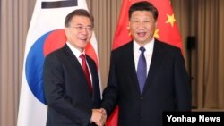 지난달 7일 문재인 한국 대통령(왼쪽)과 시진핑 중국 국가주석이 독일 베를린에서 열린 정상회담에서 악수하고 있다.