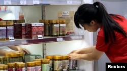 A store worker adjusts Australian products on display for sale in Sydney, Australia, Jan. 27, 2016.
