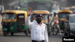 FILE - A traffic policeman wears a mask to protect himself from air pollution at a junction during restrictions on private vehicles based on registration plates, on a smoggy morning in New Delhi, India, November 4, 2019. (REUTERS/Danish Siddiqui)