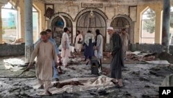 Des personnes évaluent les dégâts à l'intérieur d'une mosquée à la suite d'un bombardement dans la province de Kunduz, dans le nord de l'Afghanistan, le 8 octobre 2021. 