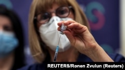 Seorang perawat menyiapkan suntikan vaksin COVID-19 dosis keempat dalam uji coba di salah satu rumah sakit di Ramat Gan, Israel, pada 27 Desember 2021. (Foto: Reuters/Ronen Zvulun)