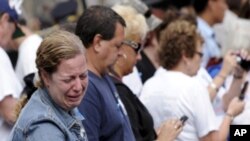 Wata mace tana kallon sunayen wadanda suka mutu tana kuka