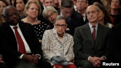 Au premier rang, trois des juges de la Cour suprême des Etats-Unis: Clarence Thomas, Ruth Bader Ginsburg et Stephen Breyer , lors de la prestation de serment de leur nouveau collègue Brett Kavanaugh, la Maison Blanche, Washington, le 8 octobre 2018.