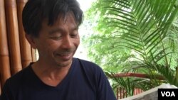 Minh Bui Jones, founder of Mekong Review, holding a copy of Mekong Review in his hands, while giving an interview to VOA Khmer's reporter Phorn Bopha, on November 16, 2015. (Photo: Phorn Bopha/ VOA) 