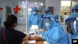 រូបឯកសារ៖ បុគ្គលិកសុខាភិបាលវៀតណាម្នាក់យកសំណាកឈាមដើម្បីធ្វើតេស្តរកជំងឺកូវីដ១៩ នៅក្រុងហាណូយ កាលពីថ្ងៃសុក្រ ទី៣១ ខែកក្កដា ឆ្នាំ២០២០។