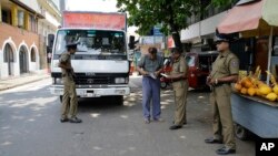 Sri Lankan police officers perform a security check on a truck at a roadside in Colombo, Sri Lanka, April 25, 2019.