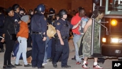 Protesters are escorted to a bus for transport after getting arrested after protesting the acquittal of Cleveland police officer Michael Brelo, May 23, 2015, in Cleveland, Ohio.