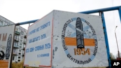 FILE - A billboard, reading "The State Central Navy Testing Range," stands near Nyonoksa, Russia, Oct. 7, 2018. An Aug. 8, 2019, explosion of a rocket engine at the Russian navy's testing range just outside Nyonoksa led to a spike in radiation levels.