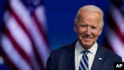 FILE - President-elect Joe Biden smiles as he speaks at The Queen theater in Wilmington, Delaware, Nov. 10, 2020. 