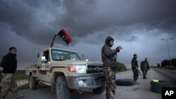 Libyan security forces stand guard at a checkpoint on the highway leading to downtown Benghazi, Libya, Feb. 15, 2013. Libyans are preparing to mark the second anniversary of the uprising that ousted Moammar Gadhafi.