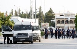 Police officers walk near the parliament building in Tunis, Tunisia, July 26, 2021.