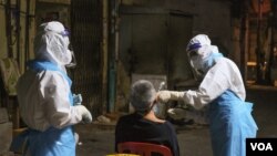 បុគ្គលិកសុខាភិបាលកំពុងយកសំណាកពីប្រជាពលរដ្ឋនៅក្នុងរាជធានីភ្នំពេញ ដើម្បីធ្វើេតស្តរកជំងឺកូវីដ១៩ កាលពីថ្ងៃទី ០៨ ខែមេសា ឆ្នាំ ២០២១។ (ទុំ ម្លិះ/វីអូអេ)