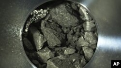 This optical microscope photo provided by the Japan Aerospace Exploration Agency (JAXA), shows soil samples seen inside C compartment of the capsule brought back by Hayabusa2. (JAXA via AP)