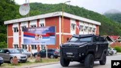 Oklopno vozilo specijalne policije Republike Srpske vozi pored bilborda sa natpisom „Mi nismo genocidni narod", u Srebrenici, BiH, četvrtak, 23.05.2024.