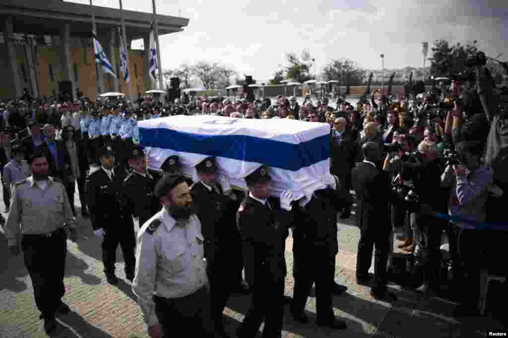 Members of the Knesset guard carry the flag draped coffin of former Prime Minister Ariel Sharon as his family members walk behind during a memorial ceremony at Israel&#39;s parliament in Jerusalem, Jan. 13, 2014.