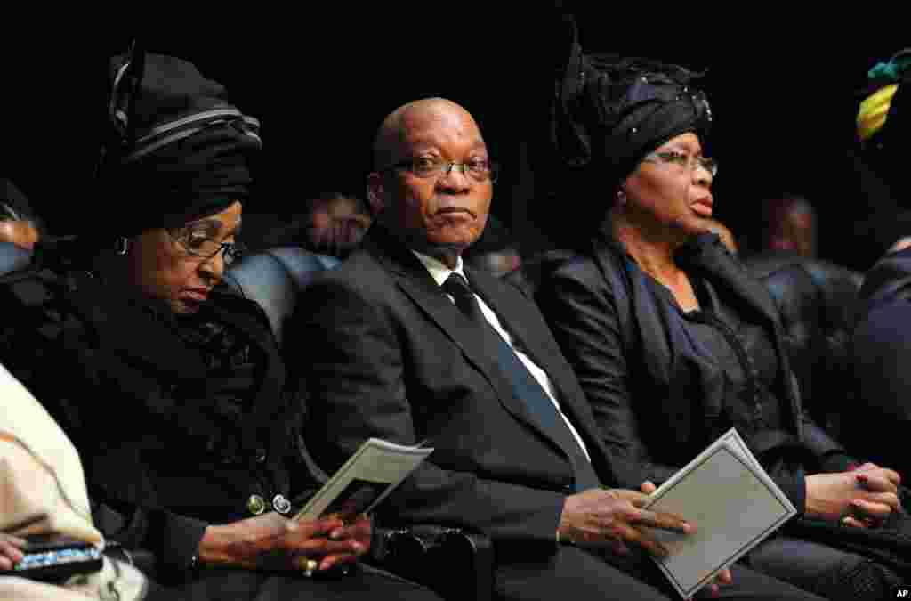 South African President Jacob Zuma sits between Winnie Madikizela-Mandela, Nelson Mandela&#39;s former wife, and Nelson Mandela&rsquo;s widow Graca Machel, right, attend the funeral service for former president in Qunu.