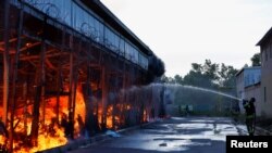 Petugas pemadam kebakaran bekerja di lokasi pusat perbelanjaan perlengkapan rumah tangga yang terkena serangan udara Rusia di Kharkiv, Ukraina, 25 Mei 2024. (Foto: REUTERS/Valentyn Ogirenko)