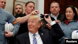 Le président américain Donald Trump distribue des stylos utilisés pour signer des ordonnances à la Maison Blanche à Washington, le 8 mars 2018.